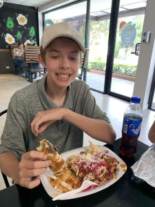 Nathan eating Honduran tacos